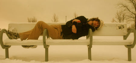 Sleeping over armrests on bench, photo by Rick Abbott